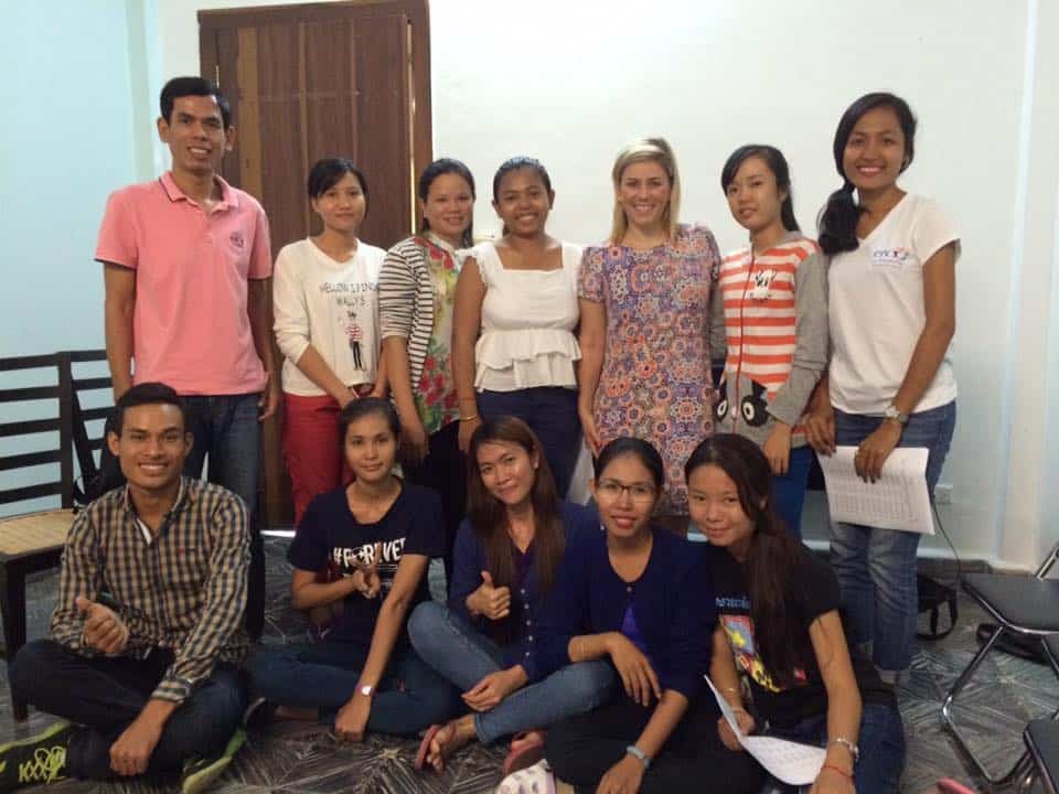 A group of newly trained Singing Guides posing in a classroom